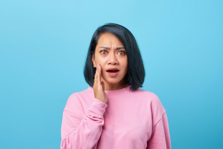 Woman experiencing jaw pain and misalignment caused by chronic stress and clenching.