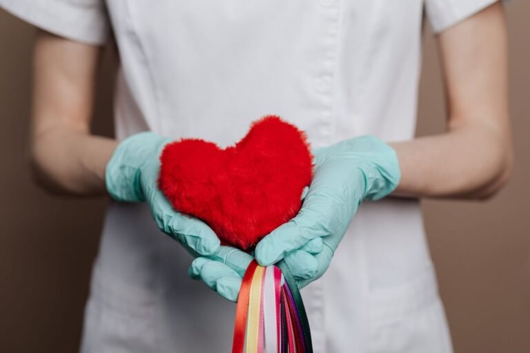 Nurse holding a red heart, representing Broken Heart Syndrome in Nurses