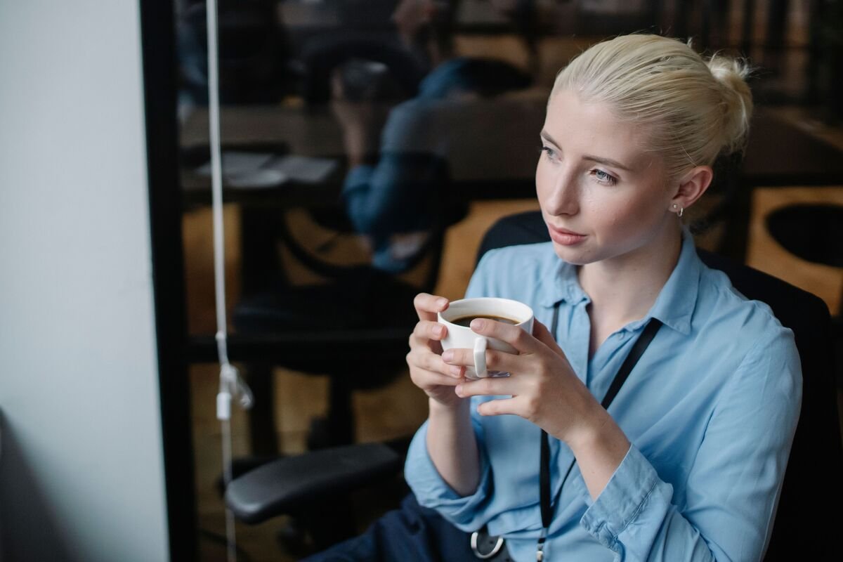 Nurse holding coffee cup, reflecting on can nurses function without coffee