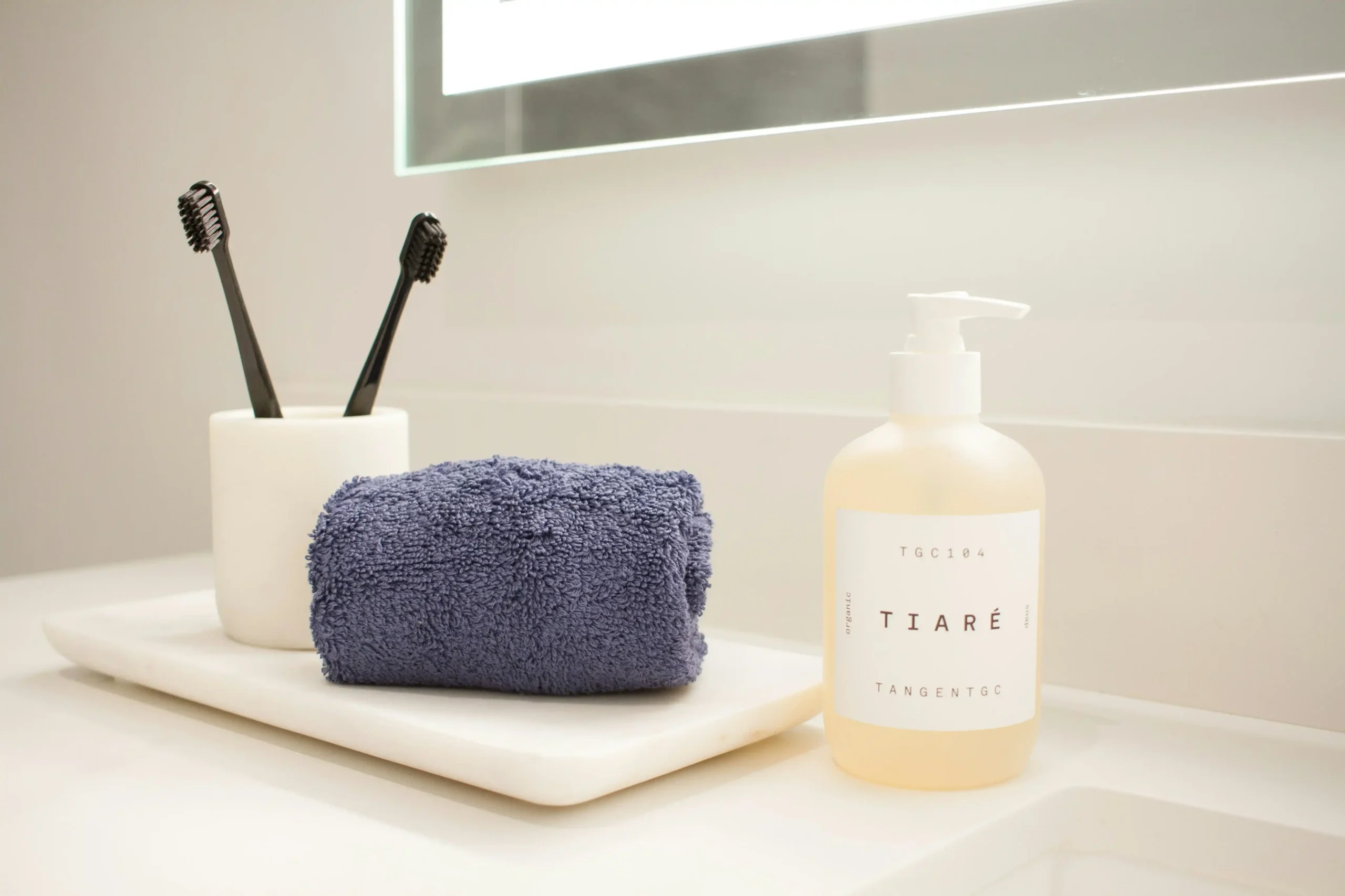 Toothbrushes and hygiene essentials on a bathroom counter, part of a daily oral care routine.