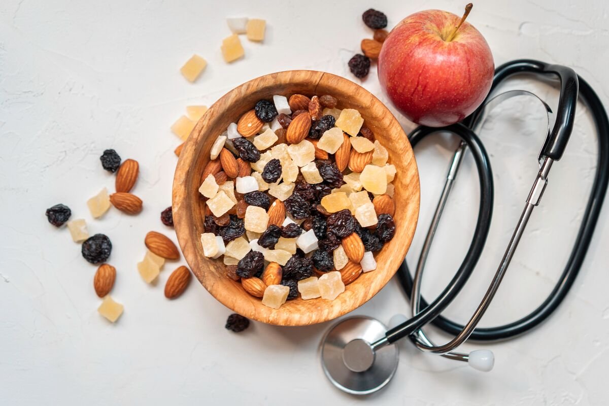 Nutrition and wellness bowl of nuts and dried fruit with a stethoscope